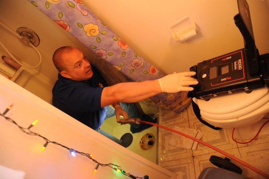 Loodgieter met een inspectiecamera in een badkamer